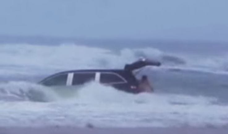 mother drives car in the ocean with kids
