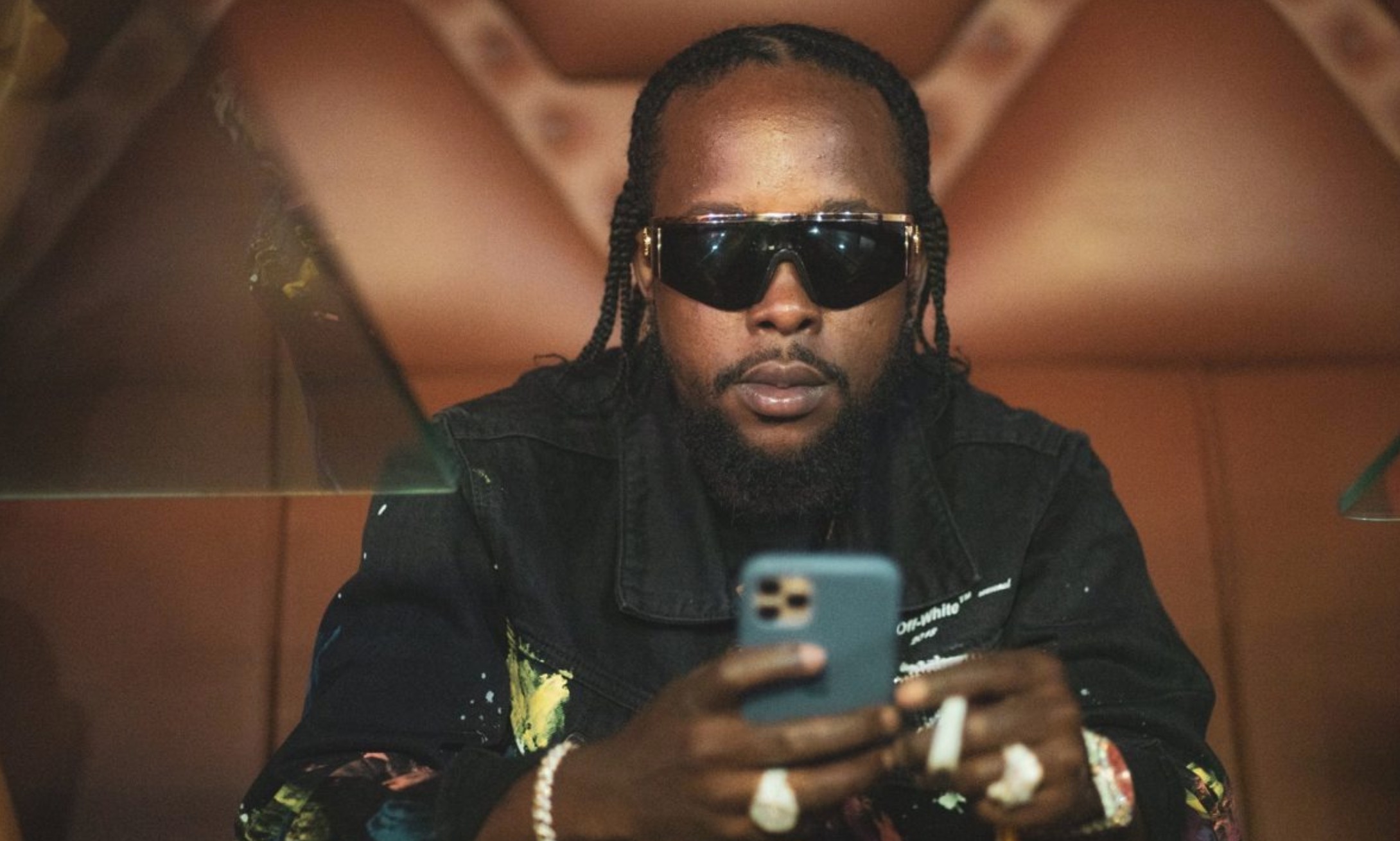 Popcaan on a phone